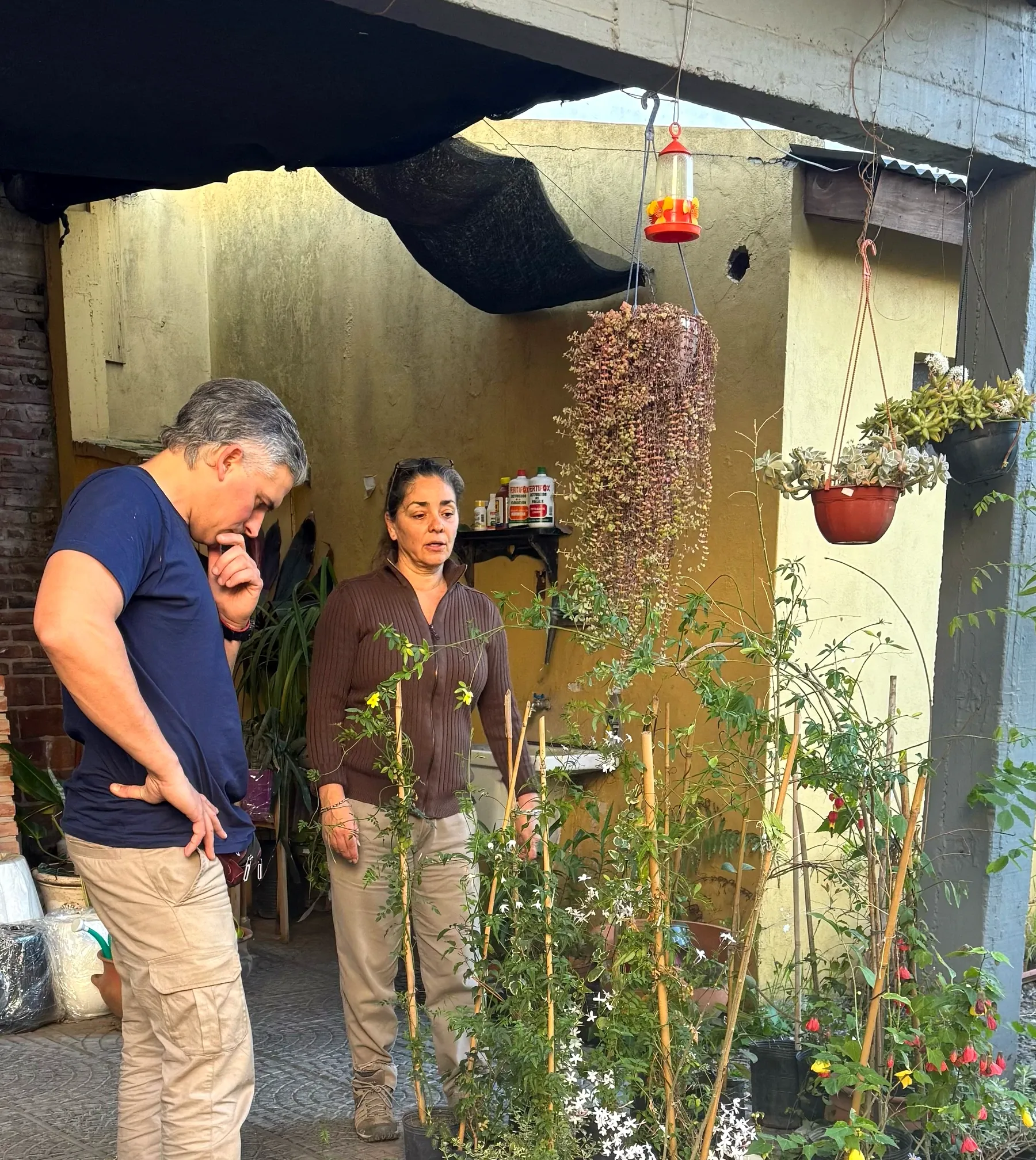 Georgina asesorando a un cliente entre las plantas del vivero